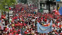 Pendukung Presiden Venezuela, Nicolas Maduro ikut ambil bagian dalam unjuk rasa memperingati May Day 2016 atau Hari Buruh Sedunia di Caracas, Minggu (1/5). Di beberapa negara, peringatan buruh sempat diwarnai dengan aksi bentrok. (REUTERS/Marco Bello)