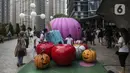 Para pengunjung berfoto dengan patung labu saat Parade Kostum Halloween di Mall Central Park, Jakarta, Sabtu (30/10/2021). Kegiatan ini juga akan diramaikan beragam makanan manis yang identik dengan makanan kecil dari kegiatan trick or treat dalam tradisi Halloween. (Liputan6.com/Johan Tallo)