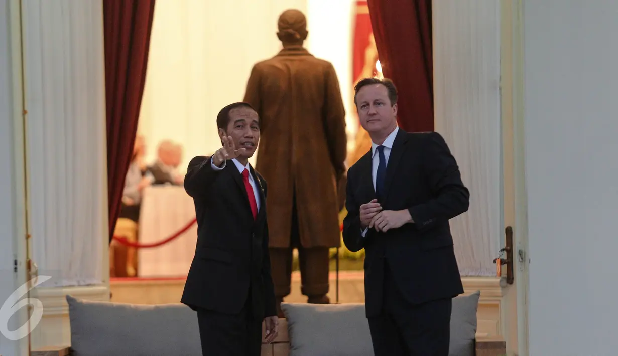 Presiden Jokowi (kiri) menunjukkan sejumlah bangunan yang ada di kompleks Istana Kepresidenan kepada PM Inggris David Cameron di Teras Istana Negara, Jakarta, Senin (27/7). (Liputan6.com/Faizal Fanani)