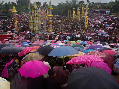 Ratusan warga dari suku India Pnar membawa payung saat menonton Festival Behdienkhlam di desa Tuber, India (24/7). Festival Behdienkhlam adalah tradisi setempat di kawasan Meghalaya yang digelar setiap tahun. (AP Photo/Anupam Nath)