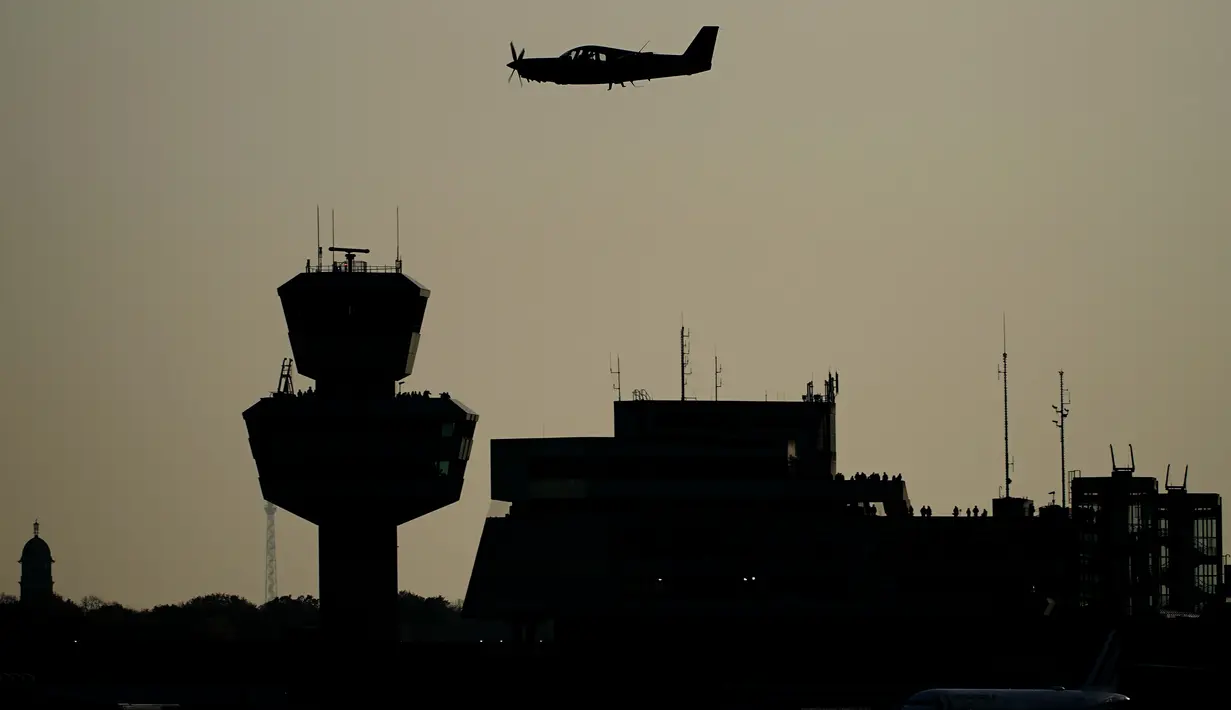 Pesawat sport ringan terbang melewati Tegel Tower, sebelum penerbangan terakhir lepas landas dari bandara Tegel (TXL) di Berlin, Minggu (8/11/2020). Maskapai Air France mendapat kehormatan sebagai penerbangan terakhir dari Bandara Tegel yang ditutup untuk selamanya. (Michael Kappeler/dpa via AP)