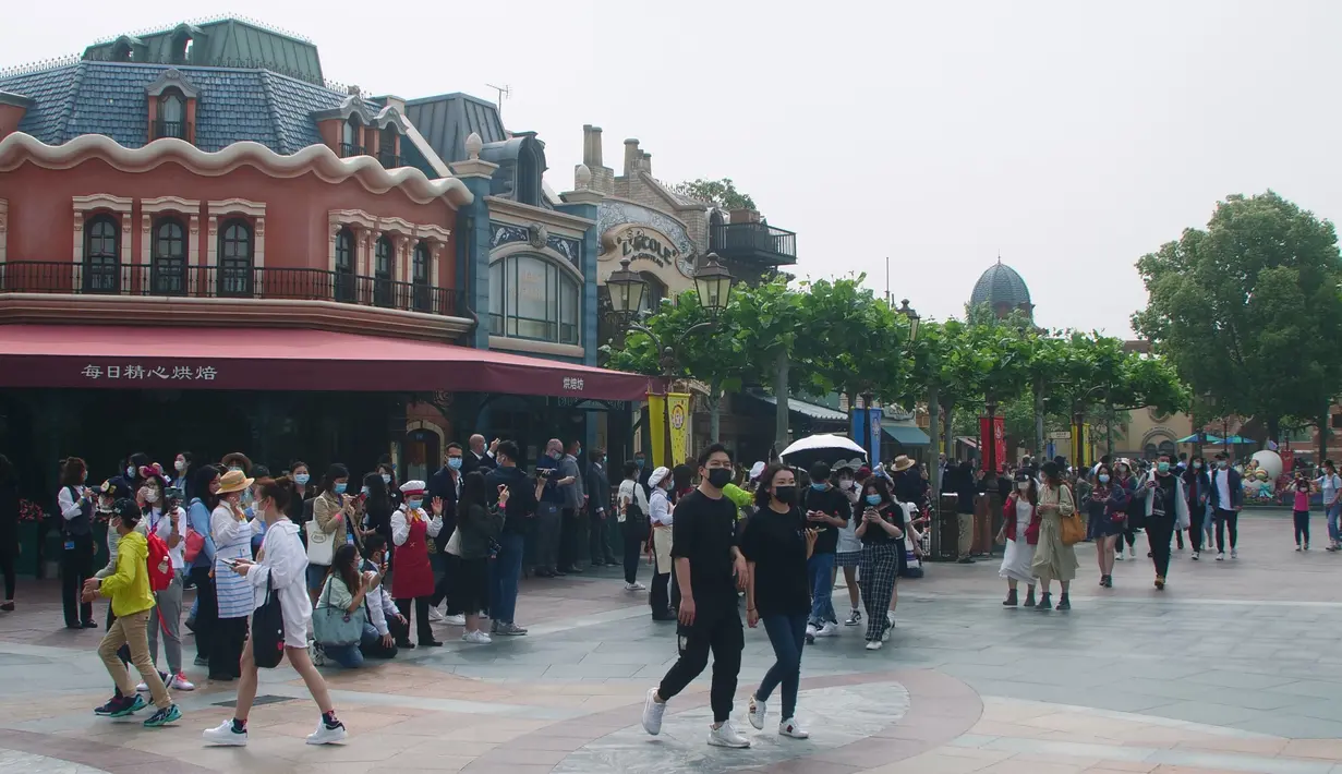 Wisatawan berjalan di taman hiburan Disneyland, Shanghai, China, Senin (11/5/2020). Walt Disney membuat langkah-langkah pencegahan dan antisipasi penyebaran COVID-19 saat kembali dibukanya Disneyland Shanghai. (AP Photo/Si Chen)