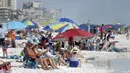 Para pengunjung berkumpul menikmati pantai di Destin, Florida, Amerika Serikat, Rabu (18/3/2020). Pantai Florida masih ramai dikunjungi pengunjung kendati virus corona COVID-19 telah menyebar ke seluruh Amerika Serikat. (Devon Ravine/Northwest Florida Daily News via AP)