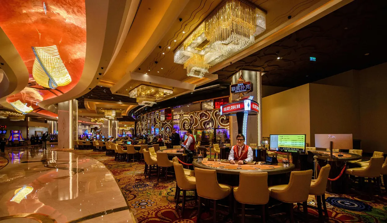 Anggota staf mempersiapkan meja kasino di resor MGM Cotai di Macau (13/2). MGM China membuka resor mega multi-miliar dolar baru di strip Cotai yang mewah di Macau pada tanggal 13 Februari. (AFP Photo/Anthony Wallace)