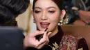 Pulasan makeup bold yang berfokus pada riasan mata yang tajam dan lipstik merah merona hasil tangan dingin makeup artist @rama_jee, buat penampilan istri Gibran Rakabuming Raka itu semakin memesona. [@rama_jee].
