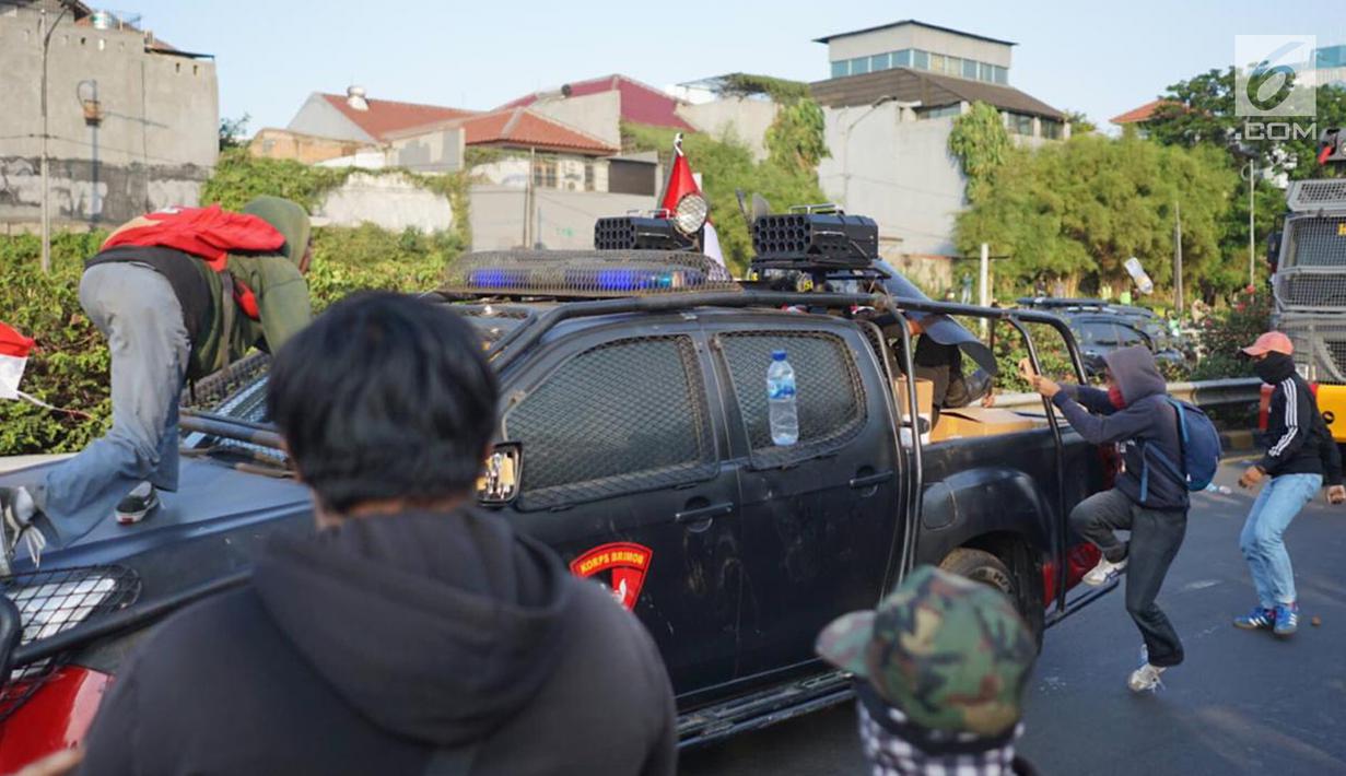 Massa pelajar menyerang kendaraan milik kepolisian yang melintas saat aksi unjuk rasa  di sekitar kawasan DPR RI, Jakarta, Senin (30/9/2019). Sempat terjadi kericuhan akibat peristiwa tersebut hingga menyebabkan jalan tol ditutup. (Liputan6.com/Immanuel Antonius)