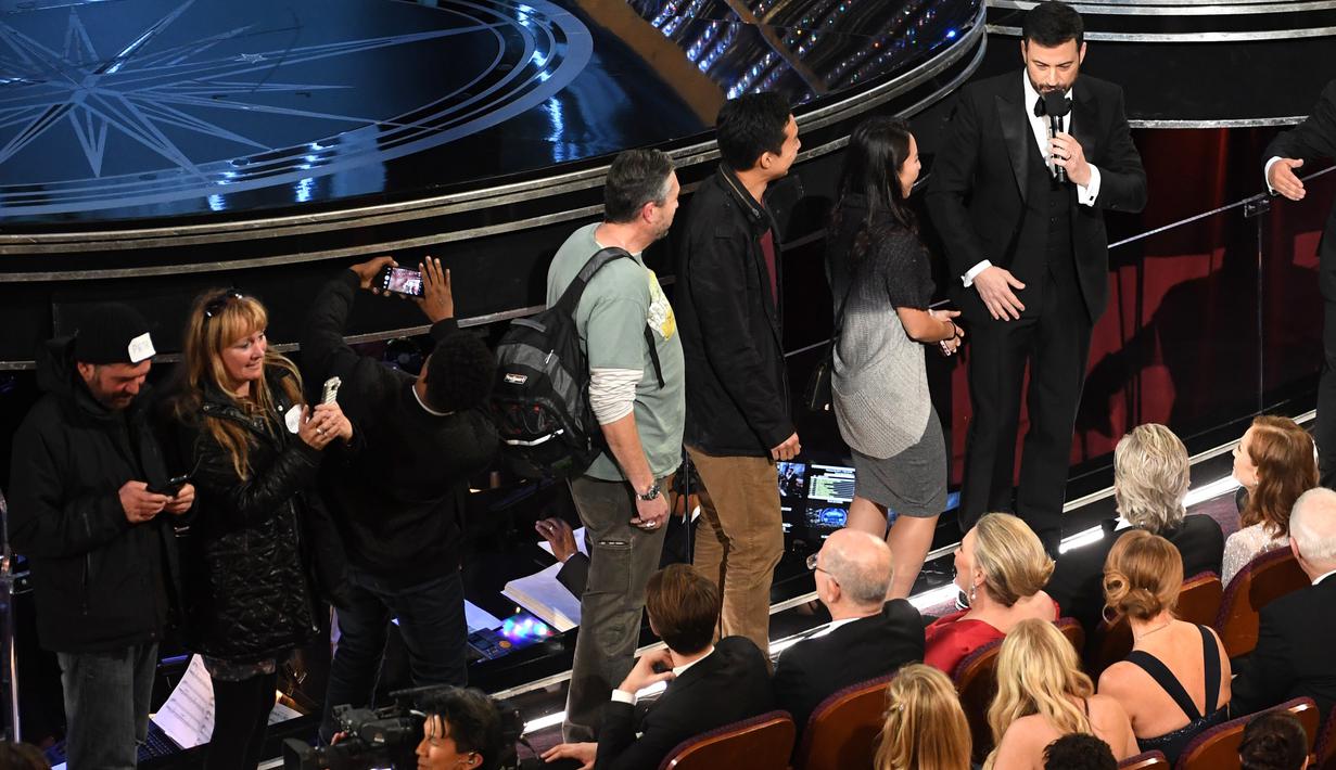 Host Piala Oscar 2017, Jimmy Kimmel mengajak masuk para turis ke perhelatan Academy Awards ke-89, di California, Minggu (26/2). Para turis ini tak pernah menyangka bahwa mereka seketika berada di dalam Dolby Theatre. (Kevin Winter/Getty Images/AFP)