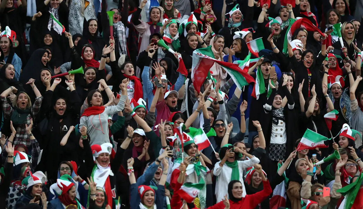 Wanita Iran bersorak saat negaranya mencetak gol ke gawang Kamboja pada laga kualifikasi Piala Dunia 2022 di Stadion Azadi, Teheran, Iran, Kamis (10/10/2019). Sebelumnya, seorang wanita membakar diri karena takut dipenjara setelah menonton bola dalam stadion. (AP Photo/Vahid Salemi)