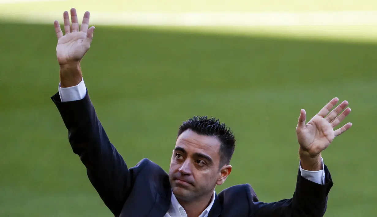 Pelatih baru Barcelona Xavi Hernandez melambai ke penonton saat presentasi resminya di stadion Camp Nou, Spanyol, Senin (8/11/2021). Barcelona menyatakan telah mencapai kesepakatan dengan Xavi dan klub yang ia tangani sebelumnya, Al-Sadd. (AP Photo/Joan Monfort)