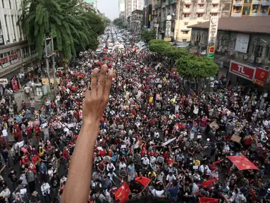 Seorang pengunjuk rasa mengacungkan salam tiga jari saat demonstrasi menentang kudeta militer di Yangon, Myanmar pada Sabtu (6/2/2021). Menurut saksi mata, aksi tersebut adalah demonstrasi jalanan terbesar yang berlangsung di Myanmar sejak kudeta hari Senin, 1 Februari lalu. (STR / AFP)