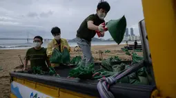 Anggota dewan distrik mengisi kantong pasir sebagai bagian dari persiapan menjelang kedatangan topan Maysak, di pantai Gwangalli di Busan (2/9/2020). Penerbangan di-grounded di Korea Selatan dan peringatan badai dikeluarkan di kedua sisi semenanjung Korea. (AFP/Ed Jones)