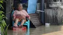 Seorang warga duduk di depan rumahnya yang tergenang banjir di kawasan Sawah besar Semarang, Jawa Tengah, Sabtu (8/12). Akibat banjir tersebut Warga pun menyelamatkan diri tanpa sempat membawa barang pribadi miliknya. (Liputan6.com/Gholib)
