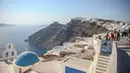 Santorini adalah persinggahan utama dalam pengalaman berlayar di Yunani. Namun karena sebagian dari pulau ini sudah hampir penuh, para pejabat sedang mempertimbangkan pembatasan. (Aris Oikonomou / AFP)