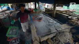 Pekerja memasak ikan asin secara tradisional di Sentra Pengolahan Ikan Asin Kampung Nelayan Muara Angke, Jakarta, Selasa (16/11/2021). Produksi ikan asin mengalami harga stabil saat pandemi Covid-19 di level 1 dengan harga jual kisaran Rp 38 ribu/kg meski cuaca kurang baik. (merdeka.com/Imam Buhori)