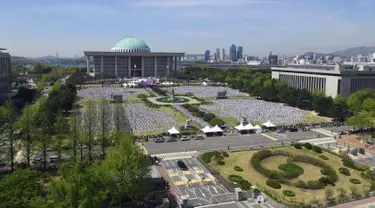 Suasana acara demonstrasi Taekwondo di luar gedung Majelis Nasional Korea Selatan di Seoul (21/5). Acara ini melibatkan sekitar 10.000 peserta termasuk anak-anak yang bertujuan memperkenalkan taekwondo sebagai seni bela diri. (AFP Photo/Jung Yeon-je)