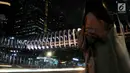 Warga menunggu kendaraan di bawah jembatan penyeberangan orang (JPO) Gelora Bung Karno (GBK), Jakarta, Senin (25/2). JPO GBK ini rencananya akan diresmikan oleh Gubenur Anies Baswedan pada Maret mendatang. (Merdeka.com/Iqbal S Nugroho)