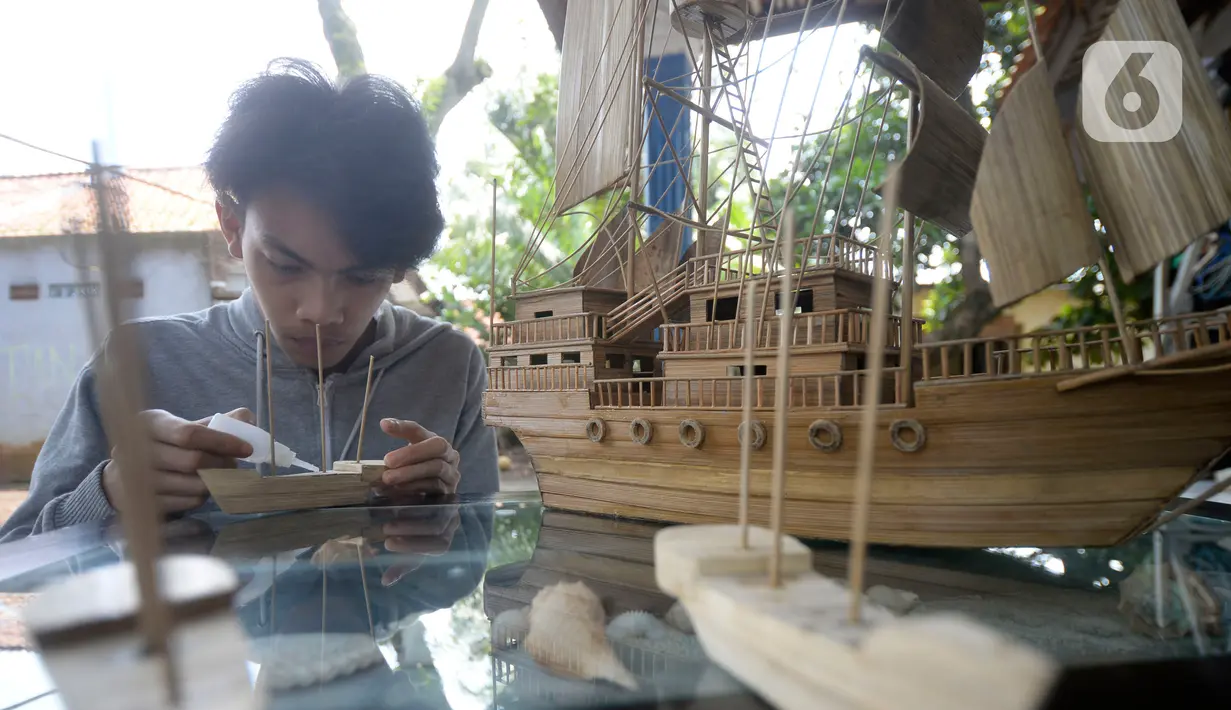 Perajin menyelesaikan pembuatan miniatur kapal pinisi yang terbuat dari limbah bambu di Pondok Benda, Pamulang, Tangerang Selatan, Senin (09/11/2020). Kerajinan berbahan bambu bekas yang dijual dengan harga berkisar Rp.50 ribu hingga Rp.250 ribu tergantung ukurannya. (merdeka.com/Dwi Narwoko)