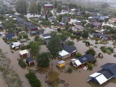 Pemandangan udara di atas area pemukiman yang terendam banjir di Gavle, Swedia, Rabu (18/8/2021). Hujan deras di Swedia timur telah menggenangi beberapa area pemukiman, dengan beberapa jalan dan jembatan tergenang saat hujan terus turun. (Fredrik Sandberg / TT via AP)