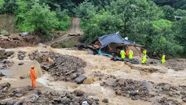 Pekerja darurat Korea Selatan mencari korban selamat di sebuah rumah yang hancur akibat banjir setelah hujan lebat di Yeongju.(AFP)