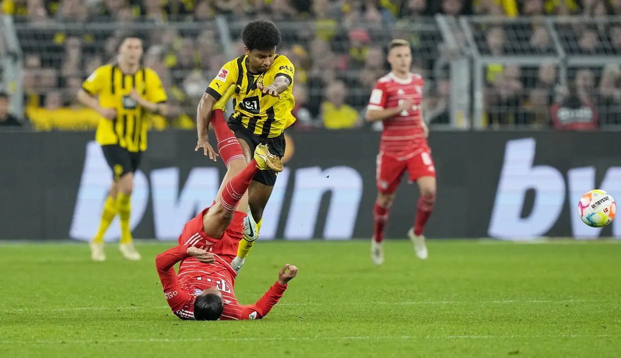 Penyerang Bayern Munchen Leroy Sane bentrok dengan penyerang Borussia Dortmund Karim Adeyemi dalam laga lanjutan Bundesliga, kasta tertinggi Liga Jerman, musim 2022-2023, di Signal-Iduna Park, Sabtu (9/10/2022). Dortmund menguntit di posisi keempat dengan poin sama tapi kalah selisih gol. (AP Photo/Martin Meissner)