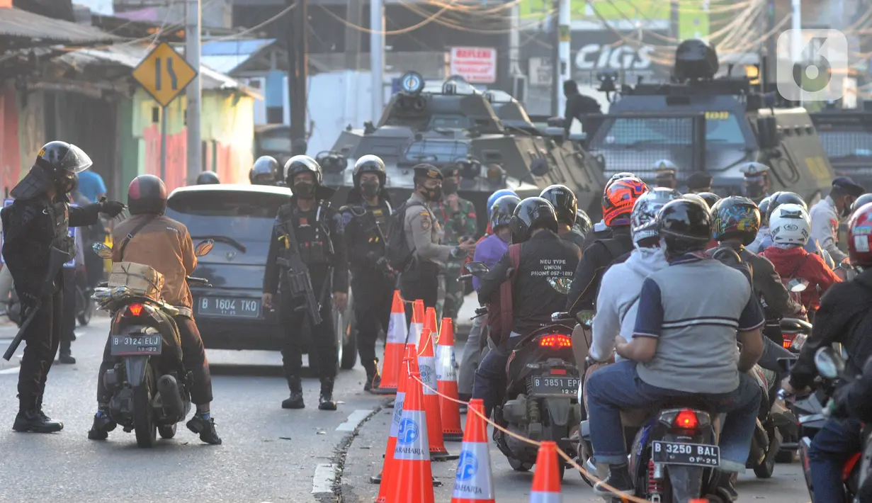 Aparat gabungan dari TNI-POLRI dan Dishub memeriksa kelengkapan dokumen pengendara bermotor  yang melintasi kanalisasi pos penyekatan PPKM Darurat di Jalan Raya Lenteng Agung, Jakarta, kamis (8/7/2021). (merdeka.com/Arie Basuki)