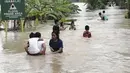 Warga mengarungi banjir akibat topan Conson di Ormoc City, provinsi Leyte, Filipina (7/9/2021). Biro cuaca mengatakan topan Conson melemah menjadi badai tropis yang parah. (AP Photo/Roberto Dejon)