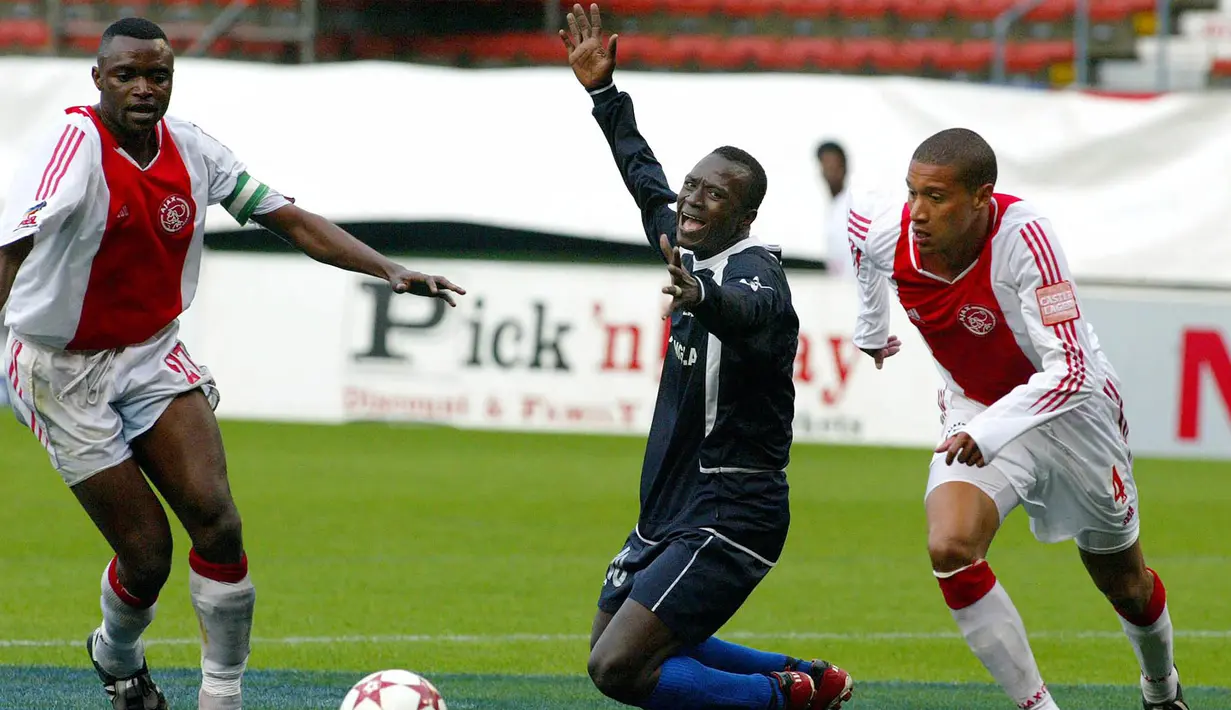 Pemain Ajax Cape Town, Dominic Isaacs (kanan) berebut bola dengan pemain Fello Star Guinea pada laga putaran ketiga Liga Champion Afrika di Newlands Stadium, Cape Town (10/4/2005). Ajax Cape Town didirikan pada tahun 1999 oleh Ajax sendiri untuk dijadikan sebagai klub satelit. Sejak 1 Oktober 2020, Ajax Cape Town tak lagi memiliki hubungan dengan Ajax setelah pihak Ajax menjual 51 persen sahamnya di Cape Town. (AFP/Rodger Bosch)
