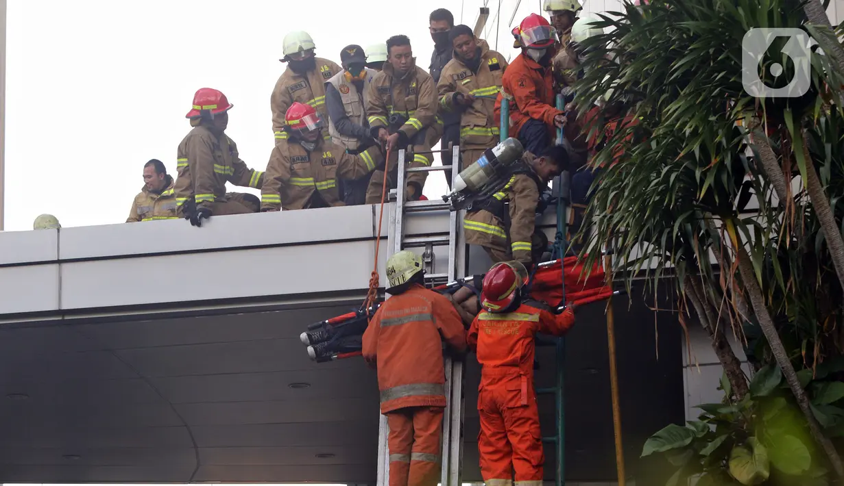 Petugas mengevakuasi korban kebakaran di Gedung Cyber 1, Jakarta, Kamis (2/12/2021). Sampai saat ini, penyebab kebakaran masih belum diketahui. (Liputan6.com/Herman Zakharia)