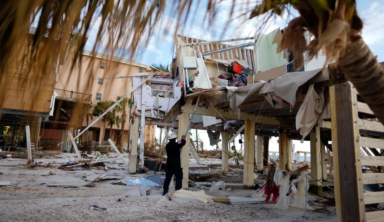 Seorang Anggota Tim Pencarian dan Penyelamatan Kota menandai sebuah bangunan kondominium yang telah diperiksa dan ditemukan bersih dari orang-orang setelah diterjang Badai Ian di Pulau San Carlos, Pantai Fort Myers, Florida, Rabu (5/10/2022). Banyak bisnis dan komunitas yang hancur akibat terjangan Badai Ian di pantai tersebut. (AP Photo/Rebecca Blackwell)