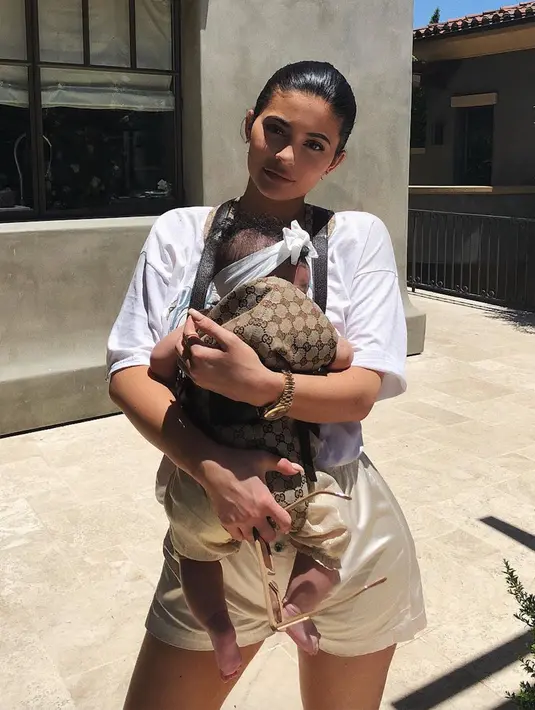 Tanpa makeup tebal dan baju longgar, Kylie Jenner terlihat sederhana saat menggendong Stormi. (instagram/kyliejenner)