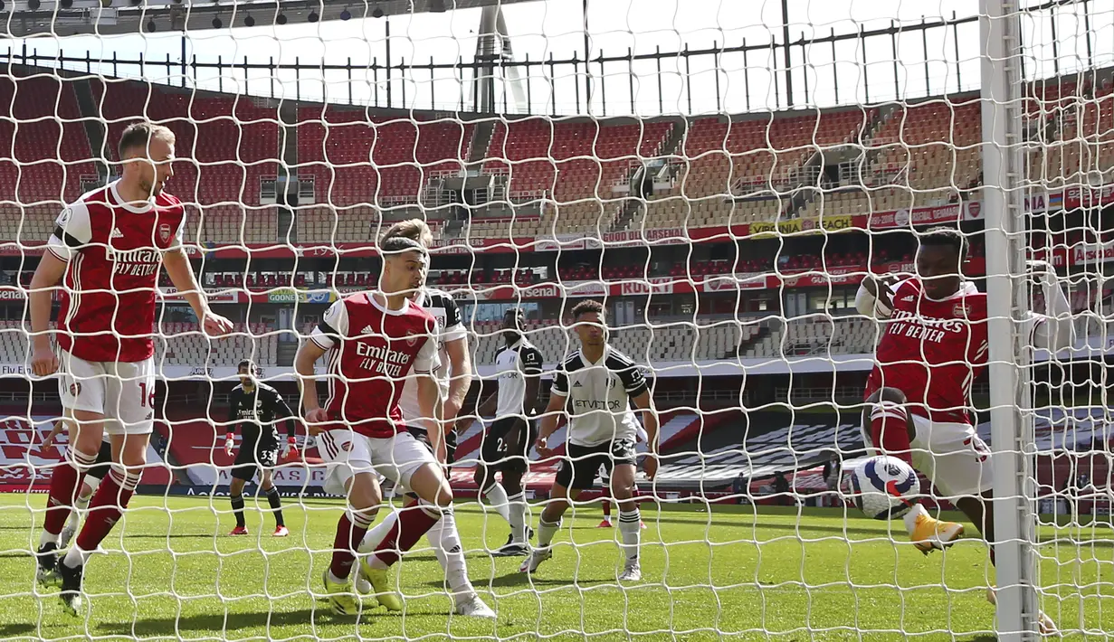 Striker Arsenal, Eddie Nketiah (kanan) mencetak gol penyeimbang 1-1 ke gawang Fulham di masa injury time dalam laga lanjutan Liga Inggris 2020/2021 pekan ke-32 di Emirates Stadium, Minggu (18/4/2021). Arsenal bermain imbang 1-1 dengan Fulham. (AFP/Walton/Pool)
