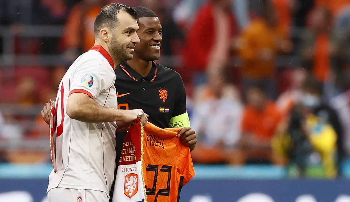 Belanda diwakili kapten mereka, Georginio Wijnaldum memberikan penghormatan berupa jersey yang bertuliskan Pandev dan bernomor punggung 122 seusai pertandingan antara Makedonia Utara melawan Belanda di Grup C Piala Eropa 2020. (Foto: AFP/Pool/Koen van Weel)