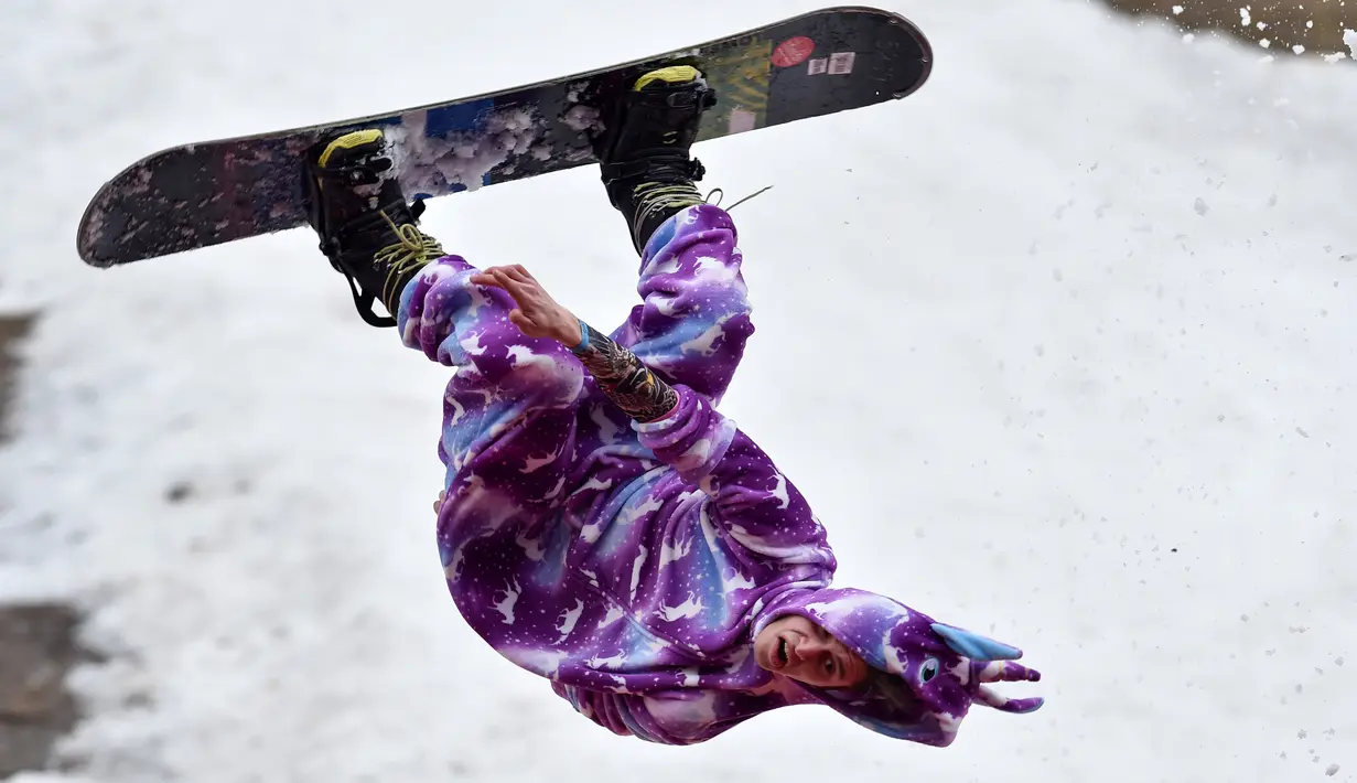 Seorang peserta mengenakan kostum sambil melakukan backflip sebagai bagian dari kompetisi komik 'Californication 9.0' di kota Logoisk, utara Minsk, Belarus, 7 April 2019. Sebanyak 8 peserta dengan kostum unik berseluncur salju untuk merayakan  akhir musim dingin. (Sergei GAPON / AFP)