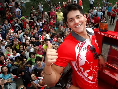 Atlet renang, peraih medali emas pertama Singapura, Joseph Schooling menyapa media di bus terbuka saat parade kemenangan di Singapura (18/08). Schooling raih medali dari cabang olahraga renang pria kategori 100 m pada Olimpiade Rio 2016(REUTERS/Edgar Su)