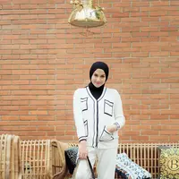 Nina Zatulini tampil elegan memadukan blus panjang bermotif dan celana kulot putih. @ninazatulini22.