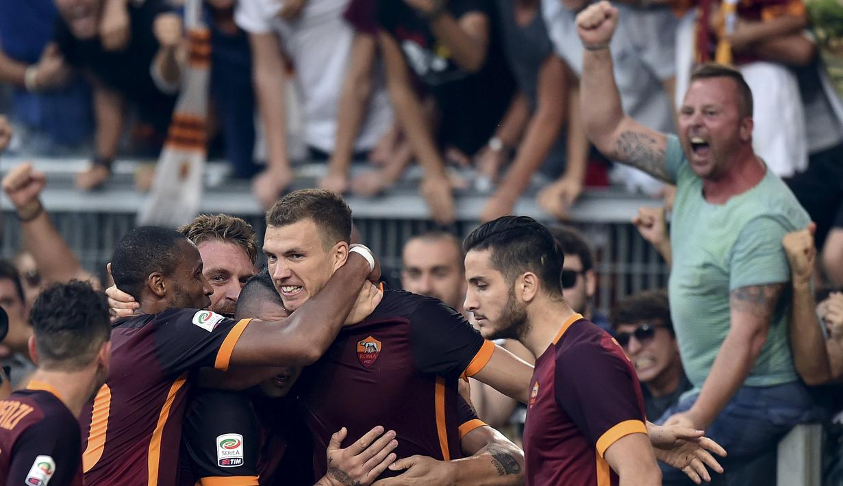 Edin Dzeko disambut rekan-rekannya setelah mencetak gol kedua Roma. Minggu (30/8/2015). (Reuters/Alberto Lingria)