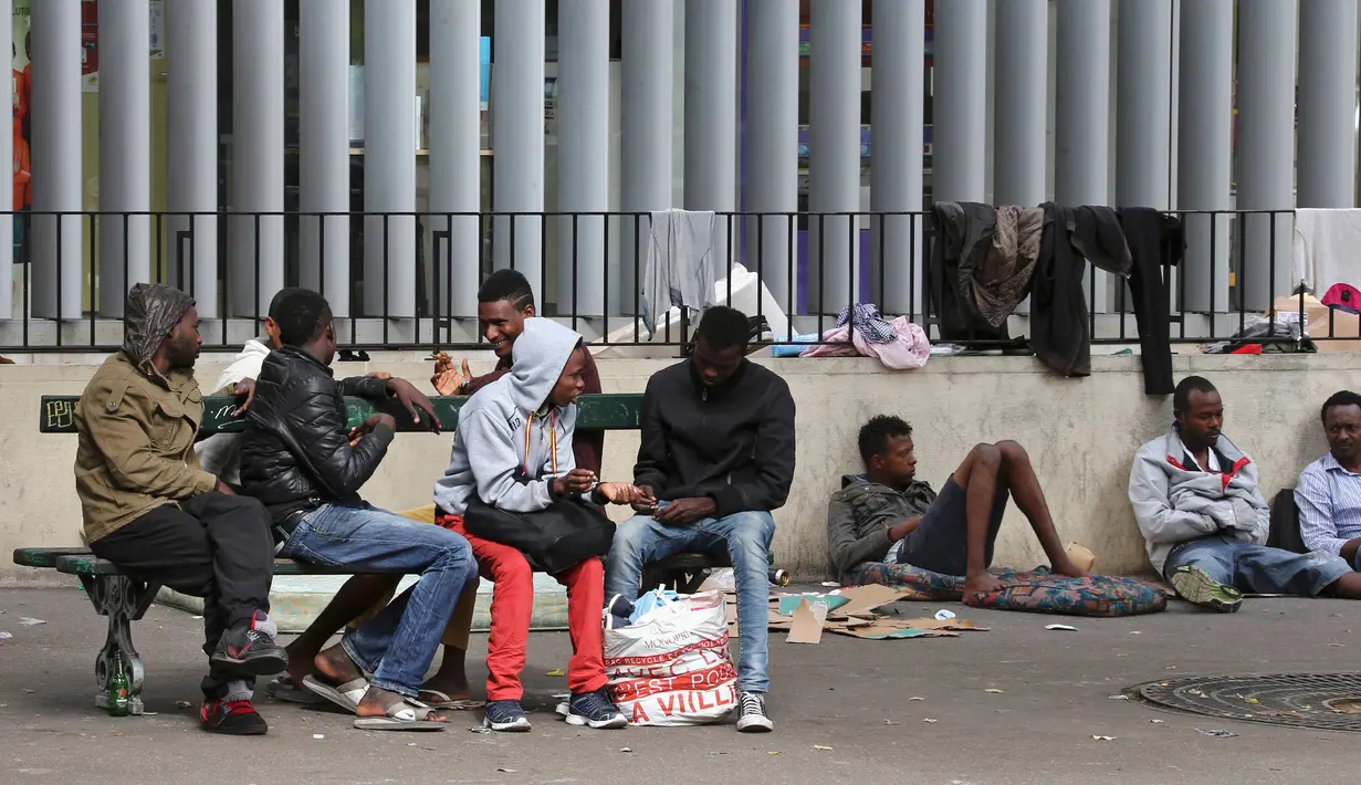 Sejumlah imigran berkulit hitam terlihat bersantai di sebuah kamp darurat di jalanan Kota Paris, Prancis, Selasa (6/9). Para imigran pencari suaka itu hidup terlantar di pinggir jalan kota tersebut. (REUTERS/Benoit Tessier)