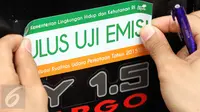 Petugas menempelkan stiker lulus uji emisi pada sebuah mobil yang telah lulus uji emisi di Jalan Proklamasi, Jakarta, Selasa (6/10/2015). Uji emisi gratis tersebut bertujuan untuk mengevaluasi kualitas udara perkotaan. (Liputan6.com/Immanuel Antonius)