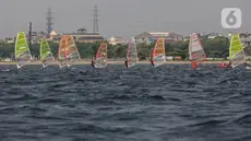 Sejumlah atlet layar beradu kecepatan saat mengikuti pertandingan Jakarta International Sailing Championship 2024 di area Symphony of The Sea, Ancol, Jumat (26/7/2024). (Liputan6.com/Angga Yuniar)