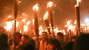 Warga berdoa sambil memegang obor saat mengikuti parade pada sebuah festival obor di Jinjiang di provinsi Fujian, China timur (24/2). Ratusan warga China mengikuti parade obor untuk keberhasilan di tahun yang baru. (AFP Photo)