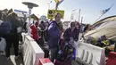 Pengungsi menunggu transportasi setelah melarikan diri dari perang dari negara tetangga Ukraina di perbatasan di Medyka, Polandia tenggara, Minggu (27/3/2022). Lebih dari 3,7 juta orang telah melarikan diri dari invasi Rusia sejauh ini, eksodus terbesar di Eropa sejak Perang Dunia II. (AP Photo/Serg