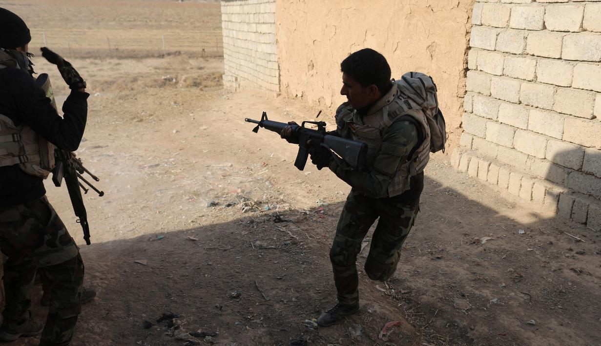 Tentara Irak berlari berlindung dibalik bangunan saat bertempur melawan militan ISIS di Al-Qasar, Tenggara Mosul, Irak, (28/11). (REUTERS/Goran Tomasevic)