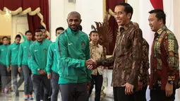 Presiden Jokowi bersalaman dengan Boaz Solossa saat menyambut kedatangan timnas Indonesia ke Istana Merdeka, Jakarta, Senin (19/12). Punggawa timnas Indonesia beserta tim sukses piala AFF memenuhi undangan makan siang bersama. (Liputan6.com/Faizal Fanani)