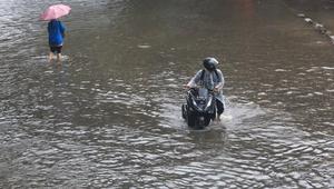Ketinggian air yang menggenangi permukiman dan jalan bervariasi, mulai dari sekitar 20 sentimeter hingga mencapai hampir satu meter di titik-titik tertentu. Tampak dalam foto, pengendara dan pejalan kaki melintasi banjir yang menggenangi Jalan Jembatan Tiga Raya, Jakarta Utara, Senin (12/1/2026). (merdeka.com/Arie Basuki)