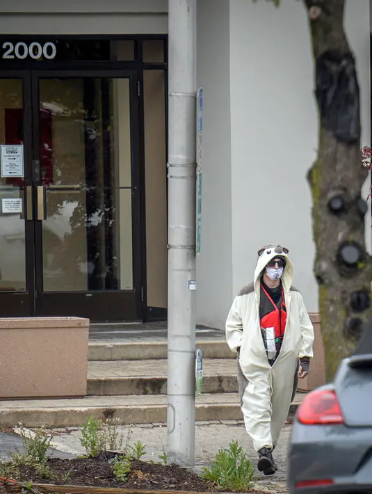 Seorang pria yang mengenakan kostum panda berjalan keluar dari stasiun televisi Fox 45 di Baltimore, Amerika Serikat (AS), Kamis (28/4). Pria itu masuk dengan benda yang ia klaim sebagai sebuah bom terpasang di dadanya. (REUTERS/Bryan Woolston)