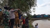 Kapolda Jabar Irjen Pol. Suntana didampingi Bupati Garut Rudy Gunawan, menunjuk daerah terdampak banjir di blok kawasan penduduk Cimacan, yang berada di samoing Cimanuk, Garut, (Liputan6.com/Jayadi Supriadin)