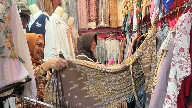 Marni Made (60) Pemilik Toko Pakaian Muslim Sedang Melayani Pembeli di Pasar Cileungsi