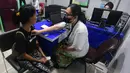 Terdapat 15 pelayanan medis yang diberikan, termasuk untuk dewasa, lansia, anak, ibu, bersalin, layanan 24 jam, serta pengendalian penyakit. Tampak dalam foto, salah satu tenaga medis sedang melakukan pemeriksaan kesehatan warga di Puskesmas Kebayoran Lama, Jakarta, Jumat (9/1/2026). (merdeka.com/Arie Basuki)