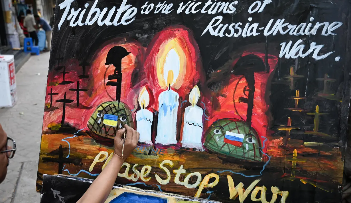 Seorang seniman mengerjakan sebuah lukisan untuk memberikan penghormatan kepada para korban perang pada malam satu tahun invasi Rusia ke Ukraina, di Mumbai, India, Kamis 23 Februari 2023. Pada 24 Februari 2022 lalu Rusia menginvasi Ukraina dan menandai puncak eskalasi konflik kedua negara sejak 2014 silam. (Punit PARANJPE/AFP)
