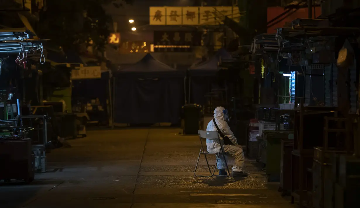 Seorang petugas kesehatan mengenakan APD berjaga di area tertutup di distrik Jordan, di Hong Kong, Minggu (24/1/2021). Hong Kong mencatat 81 kasus baru virus corona pada Sabtu (23/1), sehingga jumlah totalnya kini menjadi 10.010. (AP Photo/ Kin Cheung)